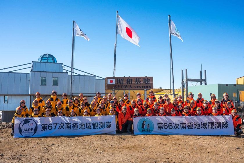 第66次隊と第67次隊の隊員が昭和基地で撮影した集合写真。KDDIからも国立極地研究所に出向し、LAN・インテルサット担当隊員として派遣、昭和基地の通信を支える役割を代々引き継いできた。提供：国立極地研究所