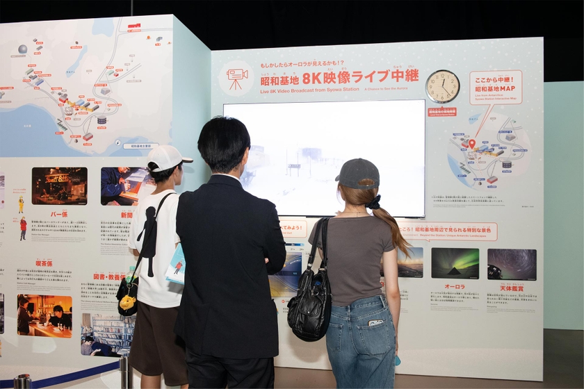 昭和基地 8K映像ライブ中継。右上の時計は昭和基地の現地時間　来場していた家族は「14,000km離れた南極の映像が、リアルタイムで見られるなんて」と画面に見入っていた