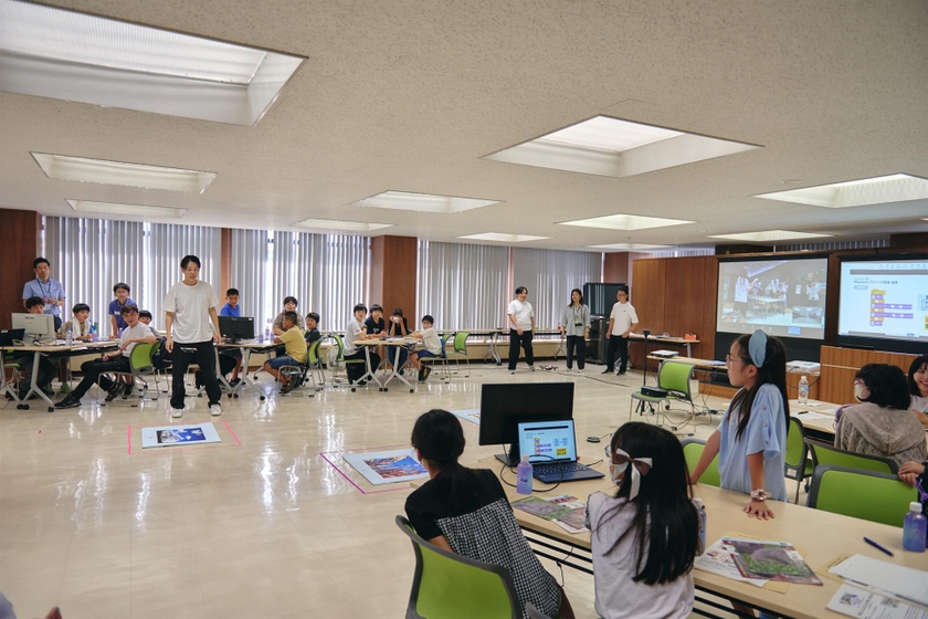 会場は池田市役所。正面のスクリーンで東京・板橋がつながる