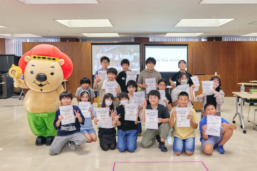 修了証を手に、池田市のマスコットキャラクターふくまるくんと記念撮影